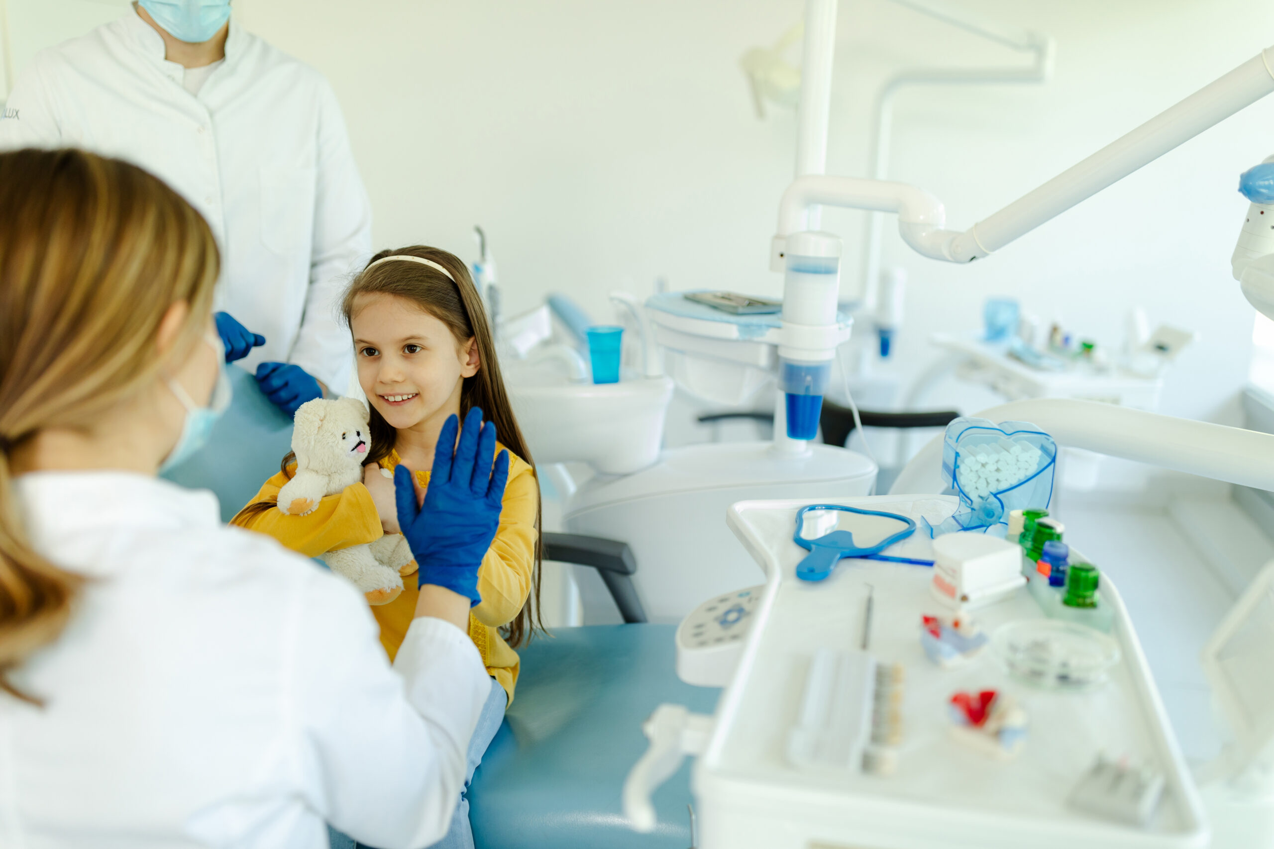 Child patient holding a teddy bear during a dental visit at Comprehensive Family Dentistry