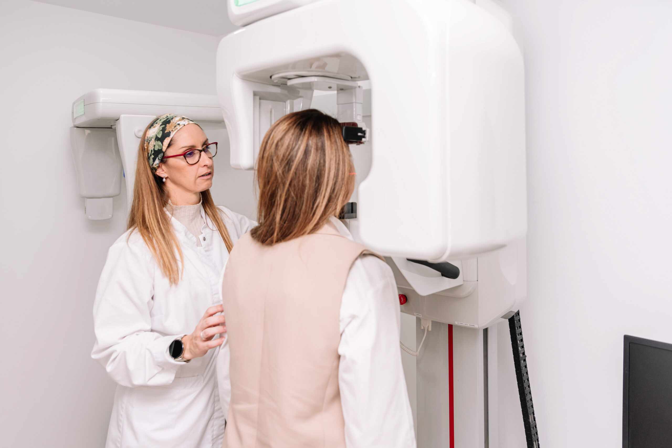 Dentist positioning a patient for advanced 3D CBCT dental imaging