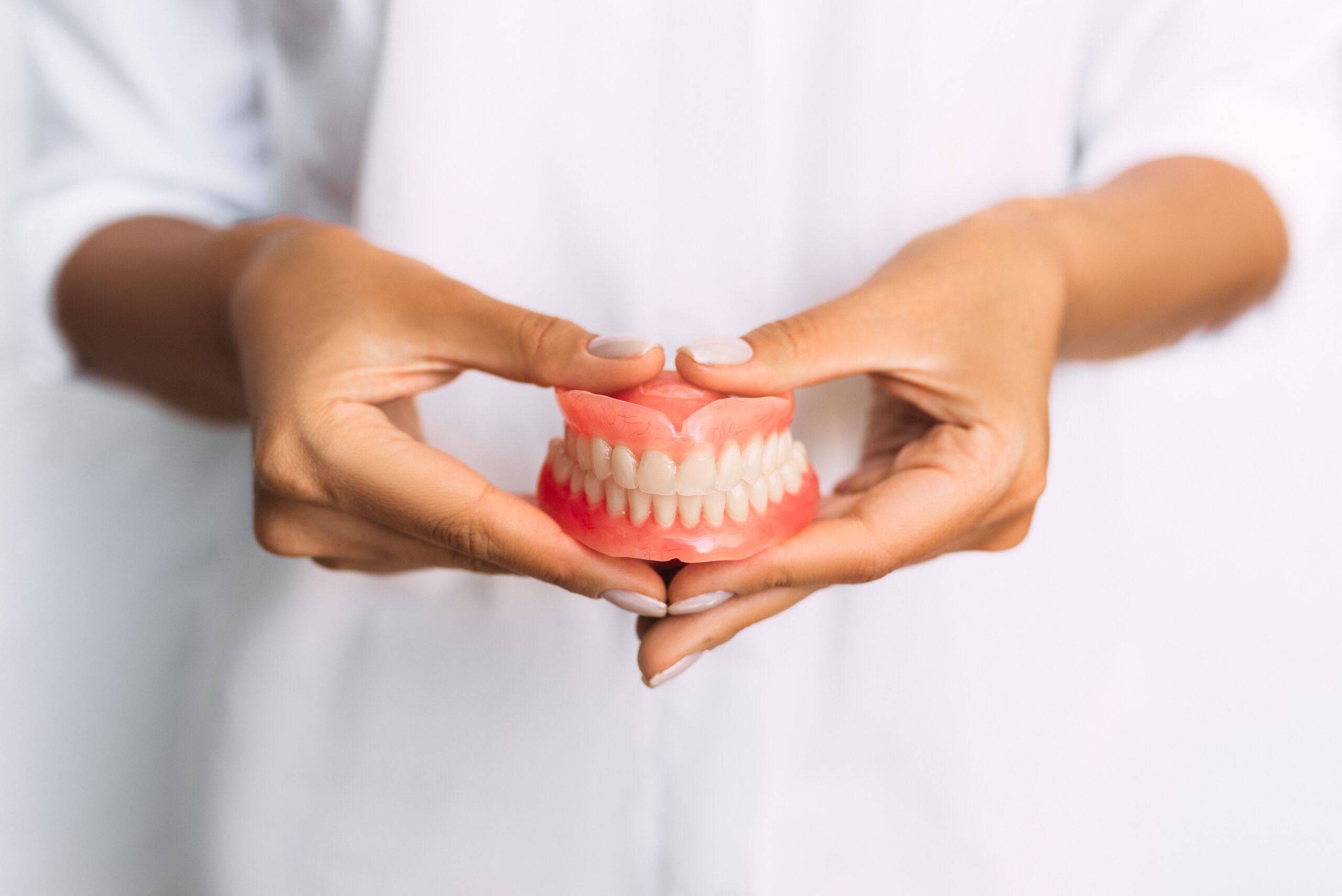 Hands holding a set of dentures