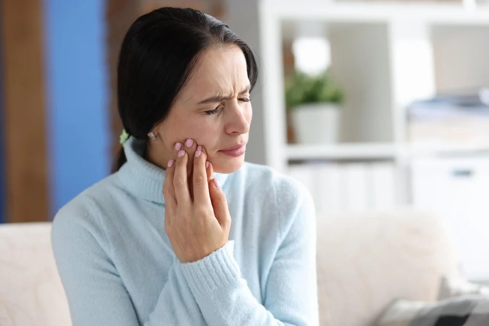 Patient experiencing jaw pain that requires emergency dental care