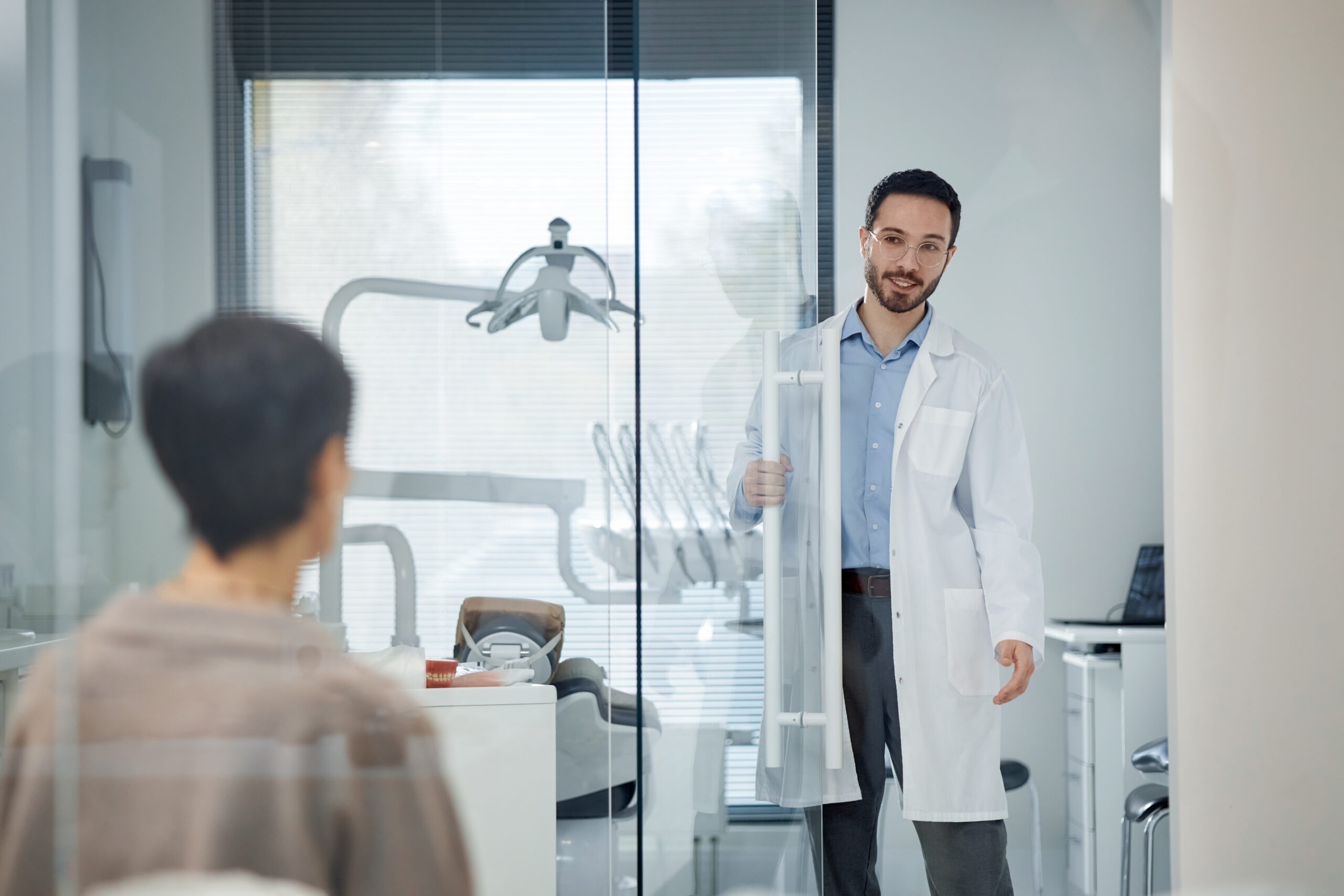 Dentist welcoming a patient into a modern dental office